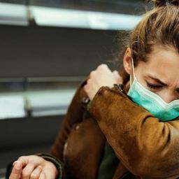 Woman with COVID mask coughing